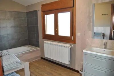 a bathroom with a sink and a tub and a window at Casa Loisiana in O Pino