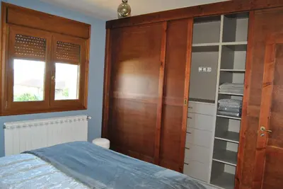 a bedroom with a wooden closet and a bed at Casa Loisiana in O Pino