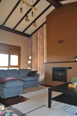 a living room with a blue couch and a fireplace at Casa Loisiana in O Pino
