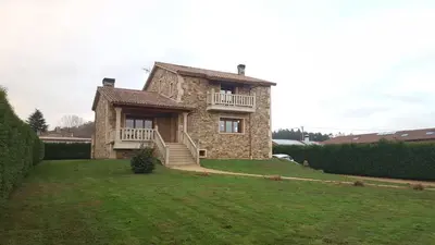 a large stone house with a balcony on a lawn at Casa Loisiana in O Pino