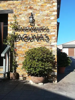 a sign on the side of a brick building at Apartamentos lagunas in Castropol