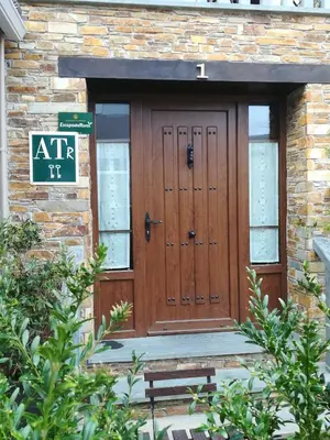 a front door of a building with a sign on it at Apartamentos lagunas in Castropol