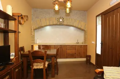 a kitchen with a table and a dining room at Apartamentos lagunas in Castropol
