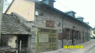 an old stone building with a gate on it at Casa los Ancares in Vega de Espinareda