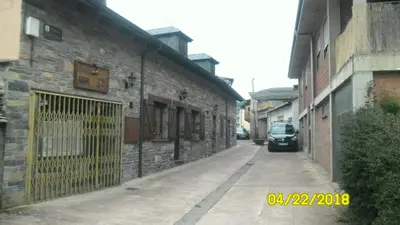 an alley with a car parked next to a building at Casa los Ancares in Vega de Espinareda