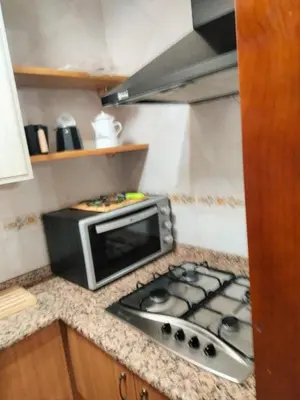 a kitchen counter with a microwave and a stove at Casa los Ancares in Vega de Espinareda