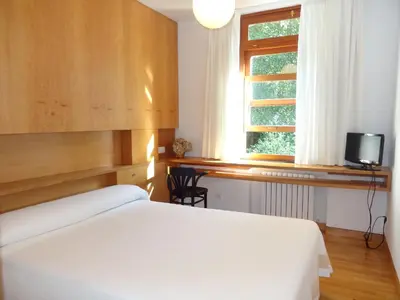 a bedroom with a white bed and a window at Hotel Restaurante Marroncín in Cangas del Narcea