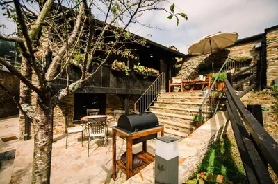 an outdoor patio with a grill and a table and stairs at Casa Calma Rural in Taramundi