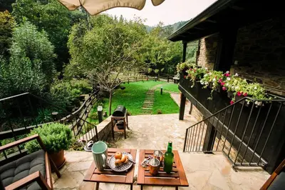 a patio with a table with a bowl of fruit at Casa Calma Rural in Taramundi