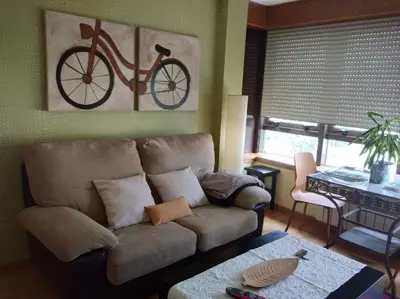 a living room with a couch and a bike on the wall at María Belkis ll in Ourense