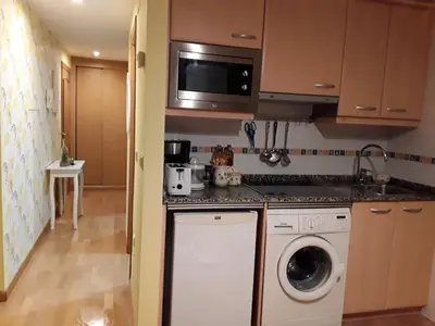 a kitchen with a washing machine and a microwave at María Belkis ll in Ourense