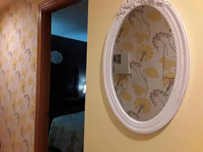 a mirror hanging on a wall next to a bedroom at María Belkis ll in Ourense