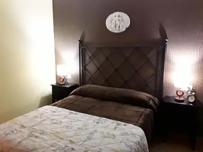 a bedroom with a large bed with two night stands at María Belkis ll in Ourense