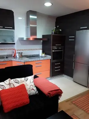 a kitchen with a black and orange couch in a kitchen at María Belkis in Ourense