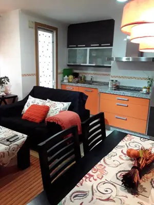 a living room with a couch and a kitchen at María Belkis in Ourense