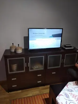 a flat screen tv on a wooden entertainment center at María Belkis in Ourense