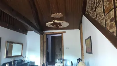a room with a wooden ceiling and a ceiling fan at La casita de la señora María in Ponferrada