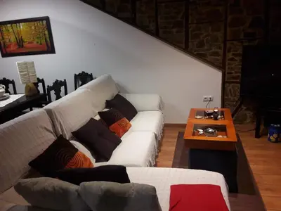 a living room with a white couch and a table at La casita de la señora María in Ponferrada