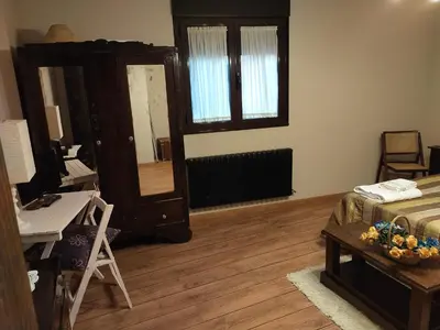 a room with a bed and a desk and a desk at La casita de la señora María in Ponferrada