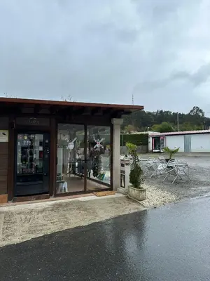 a store front with tables and chairs in a parking lot at P Residencia PIVIDAL in Picaraña