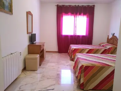 a bedroom with two beds and a window at P Residencia PIVIDAL in Picaraña