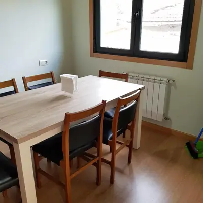 a dining room table with chairs and a window at Moreiriña- Bentraces in Bentraces