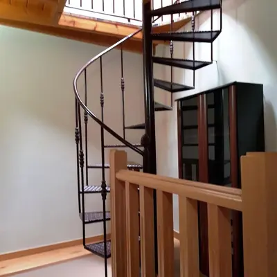 a spiral staircase in a loft conversion with wooden railings at Moreiriña- Bentraces in Bentraces