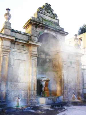 a fountain in a building with people standing around it at Moreiriña- Bentraces in Bentraces