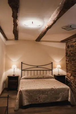 a bedroom with a bed with two lamps on two tables at Pazo de Eidian in Eidián