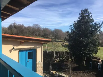 a house with a blue door and a field at Casa Antoni@ in Parada del Sil