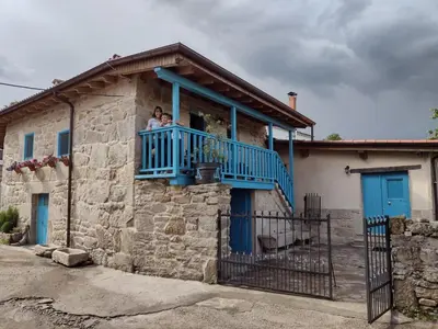 two people on a balcony of a house at Casa Antoni@ in Parada del Sil