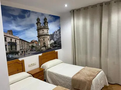 a bedroom with two beds and a picture of a tower at Camiño Portugues in Padrón