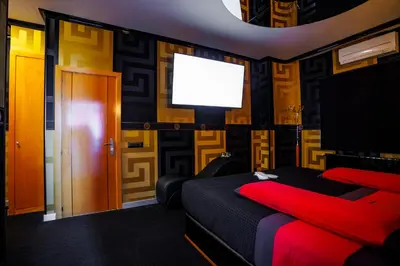 a bedroom with a red bed and a flat screen tv at Motel Venus Santiago in Luou