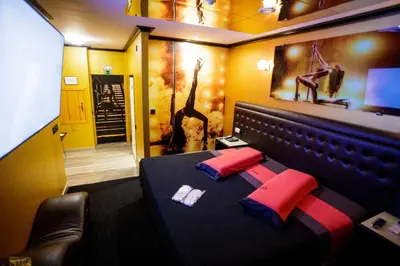 a bedroom with a bed with red and blue pillows at Motel Venus Santiago in Luou