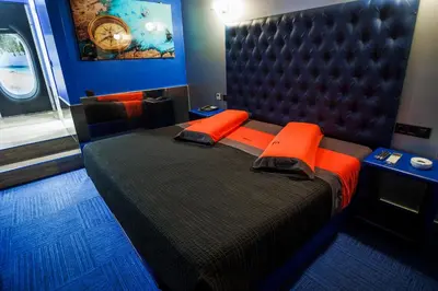 a bedroom with a large bed with orange pillows at Motel Venus Santiago in Luou