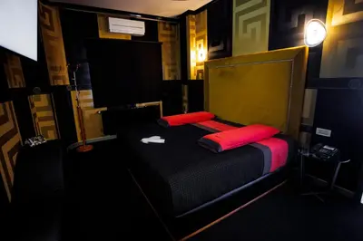 a bedroom with a bed with two red pillows at Motel Venus Santiago in Luou