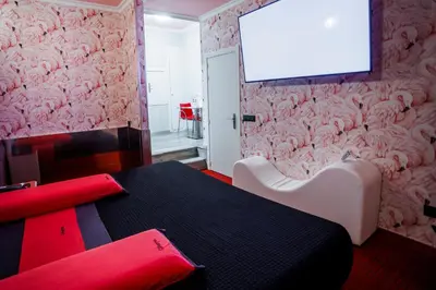 a room with a table and a tv on a wall at Motel Venus Santiago in Luou