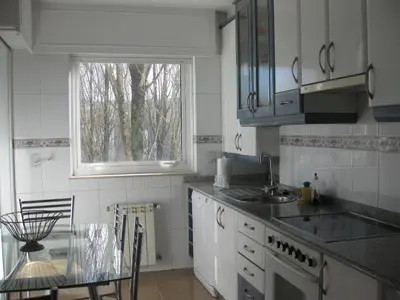 a kitchen with a table and a sink and a window at Descanso do Sar in Santiago de Compostela