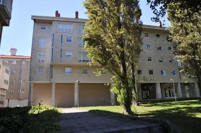 an apartment building with a garage in front of it at Descanso do Sar in Santiago de Compostela