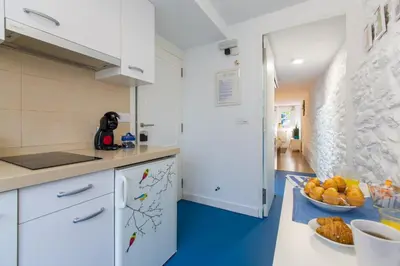 a kitchen with white cabinets and blue floors at roomPEDRA apartamentos turísticos in Santiago de Compostela