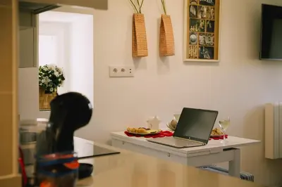 a laptop computer sitting on a table with a plate of food at roomPEDRA apartamentos turísticos in Santiago de Compostela