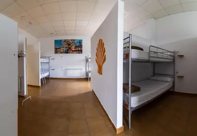 a room with two bunk beds and a hallway at Albergue Espiritu Xacobeo in O Pedrouzo