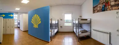 a room with bunk beds and a blue wall at Albergue Espiritu Xacobeo in O Pedrouzo