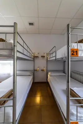 a room with three bunk beds in a dorm at Albergue Espiritu Xacobeo in O Pedrouzo