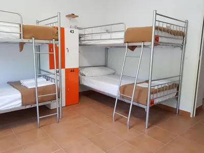 a room with two bunk beds in a dorm room at Albergue Espiritu Xacobeo in O Pedrouzo