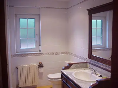 a bathroom with a sink and a toilet and a mirror at Villa Salgueiros in Teo