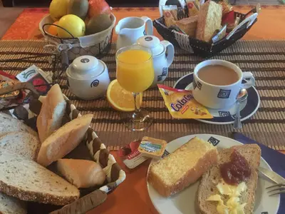 a table with a plate of bread and a cup of orange juice at Finca Galea in Carballido