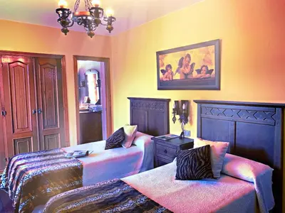a bedroom with two beds and a couch and a painting at Finca Galea in Carballido