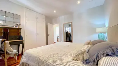 a white bedroom with a bed and a desk at Covas Seabreeze Cottage in Viveiro