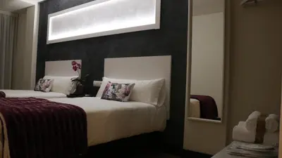 a hotel room with two beds with purple sheets at Hotel Malecon in O Barco de Valdeorras